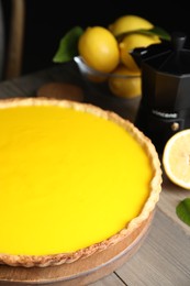 Photo of Delicious homemade lemon pie and fresh fruits on wooden table, closeup
