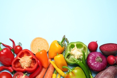 Flat lay composition with fresh vegetables on light blue background. Space for text