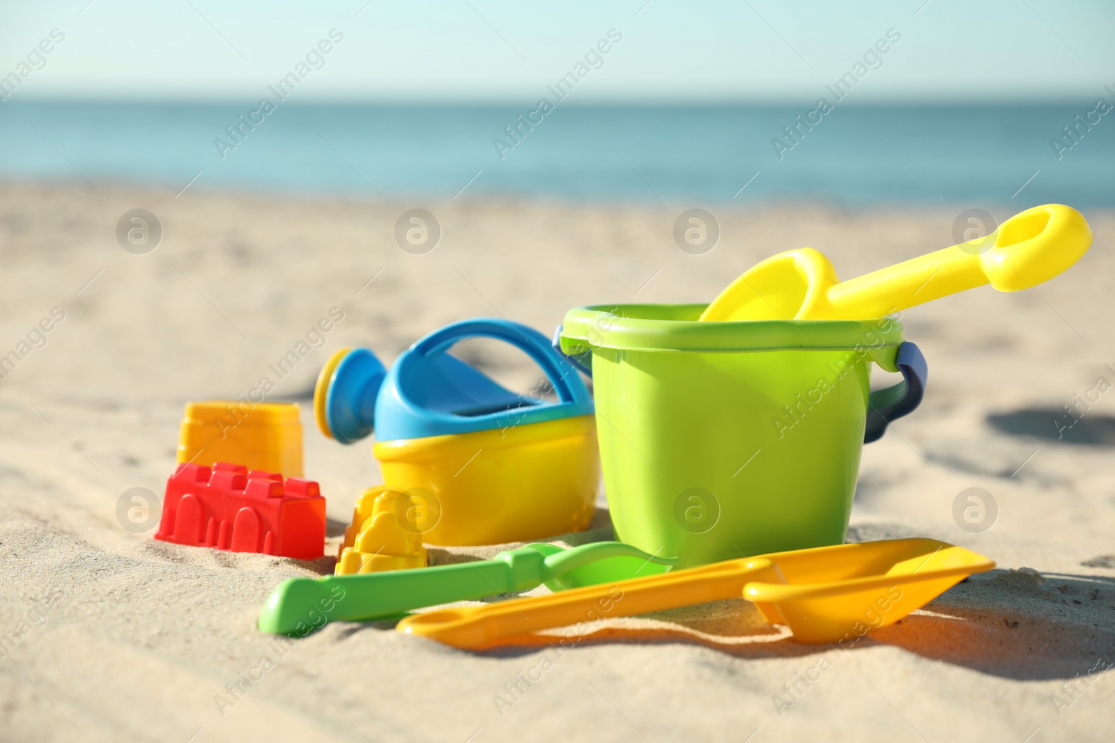 Photo of Different child plastic toys on sandy beach