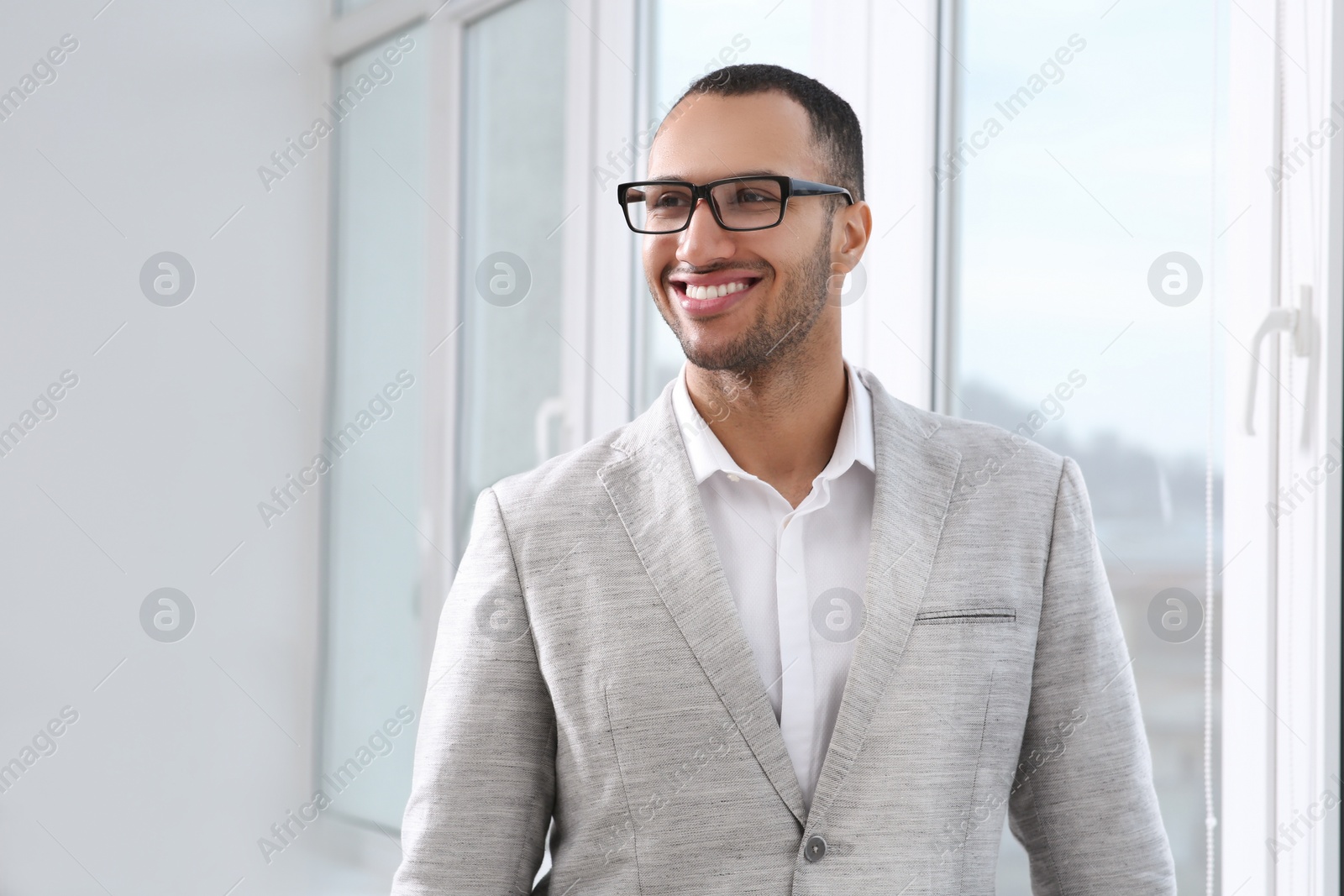 Photo of Smiling young businessman in his modern office