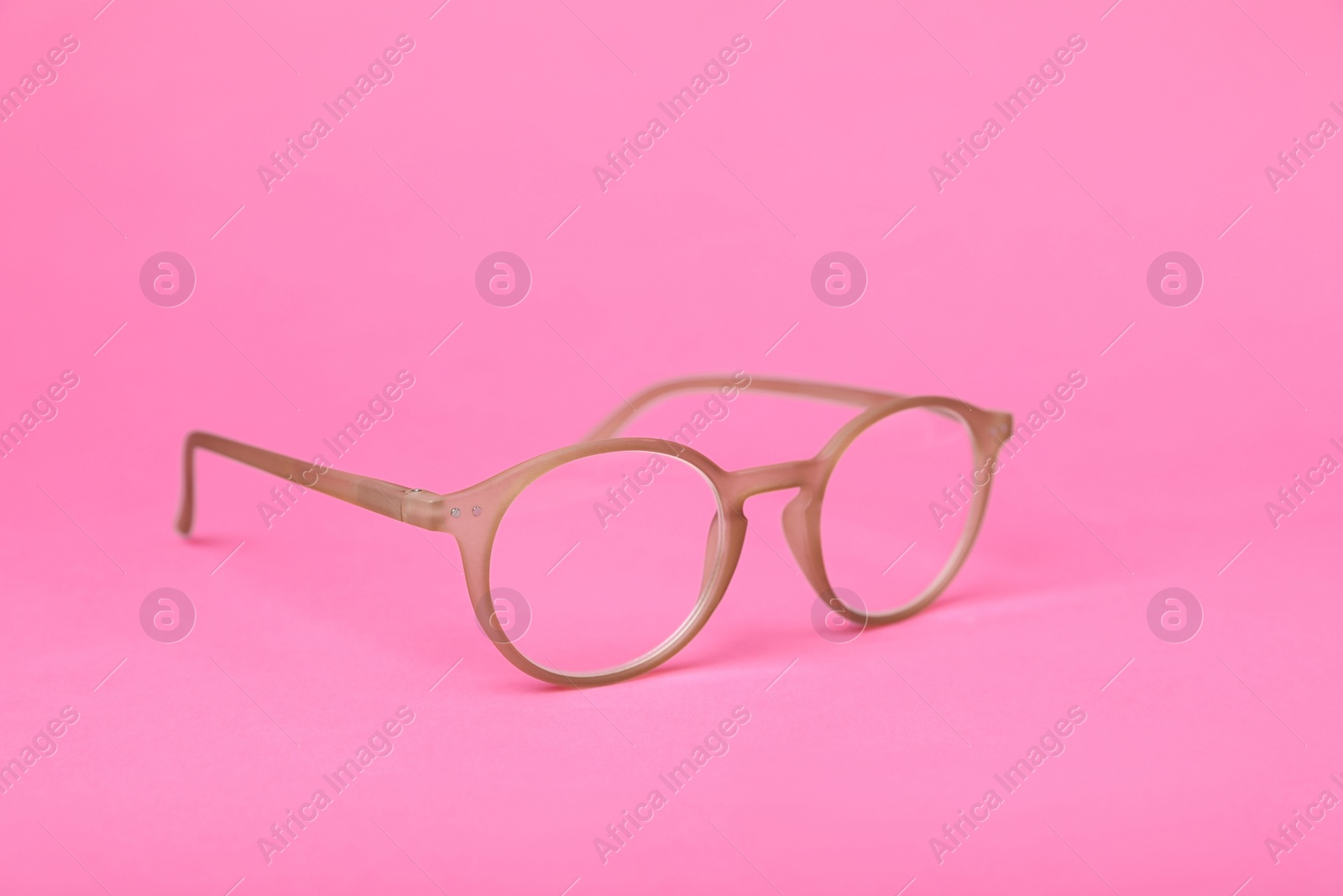 Photo of Glasses with corrective lenses on bright pink background