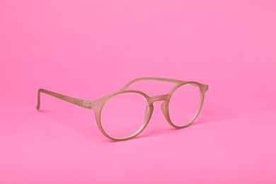 Photo of Glasses with corrective lenses on bright pink background