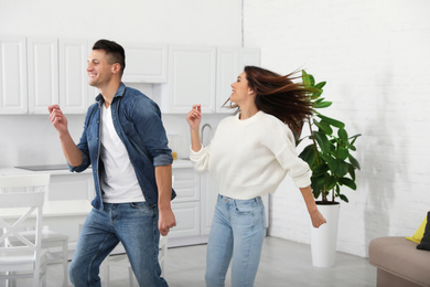 Photo of Happy couple dancing in kitchen at home