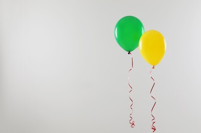 Different bright balloons on light background, space for text. Celebration time