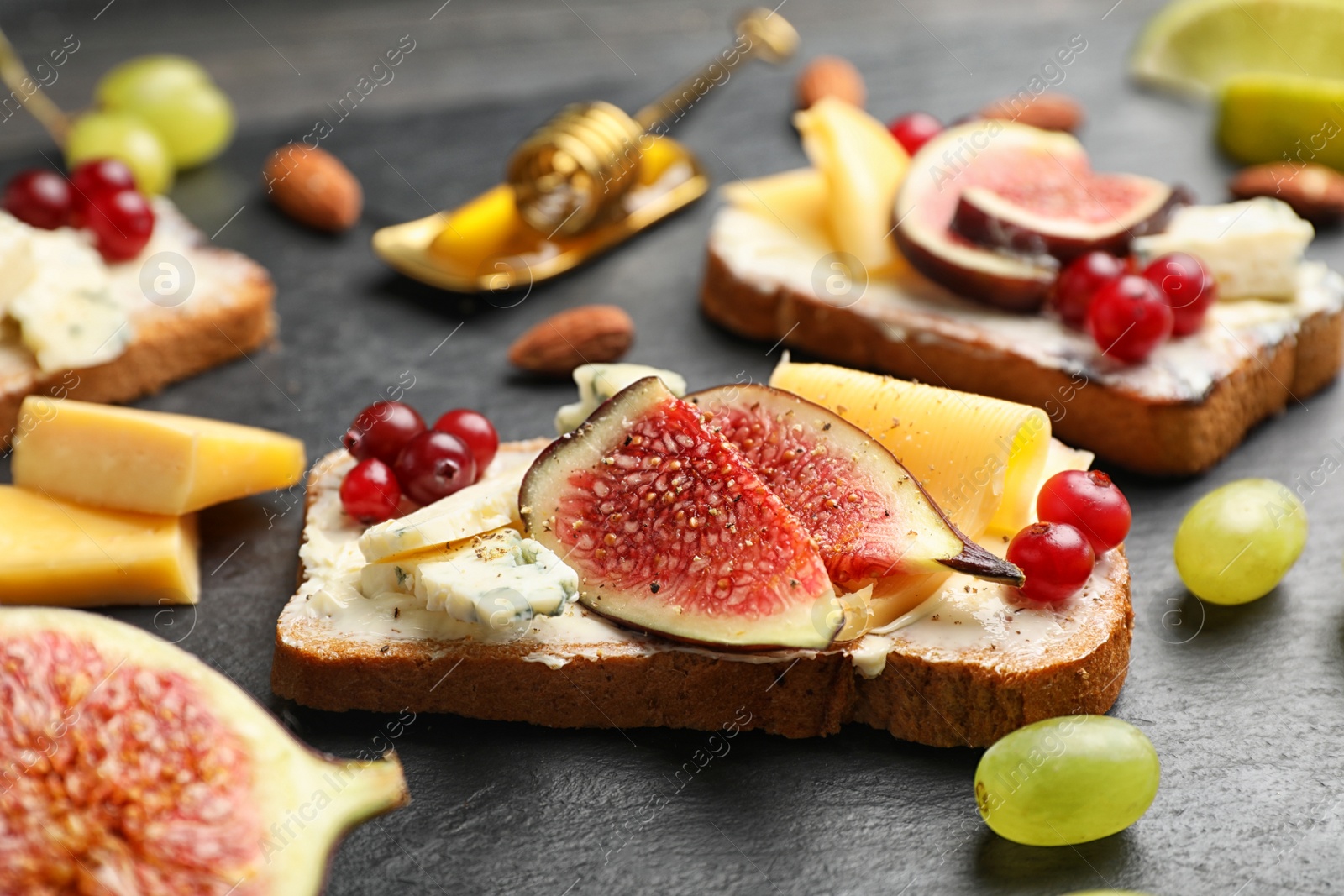 Photo of Sandwich with ripe fig slices on black table, closeup