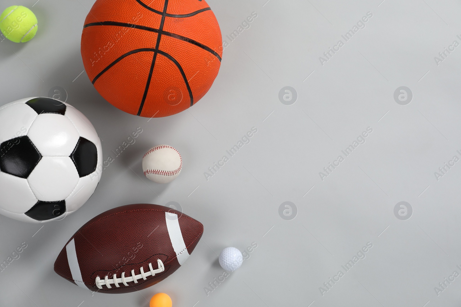 Photo of Many different sports balls on gray background, flat lay. Space for text