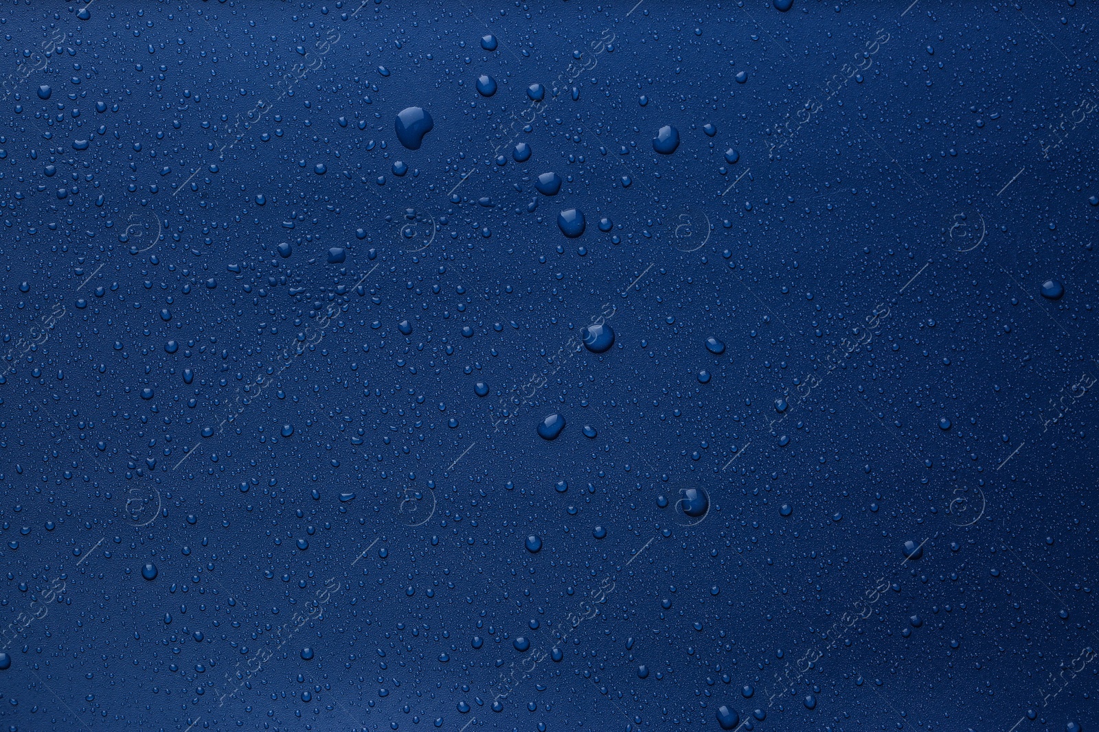 Photo of Many water drops on bright blue background