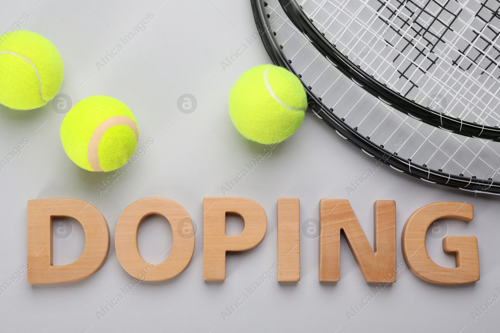 Photo of Word Doping, tennis rackets and balls on light grey background, flat lay