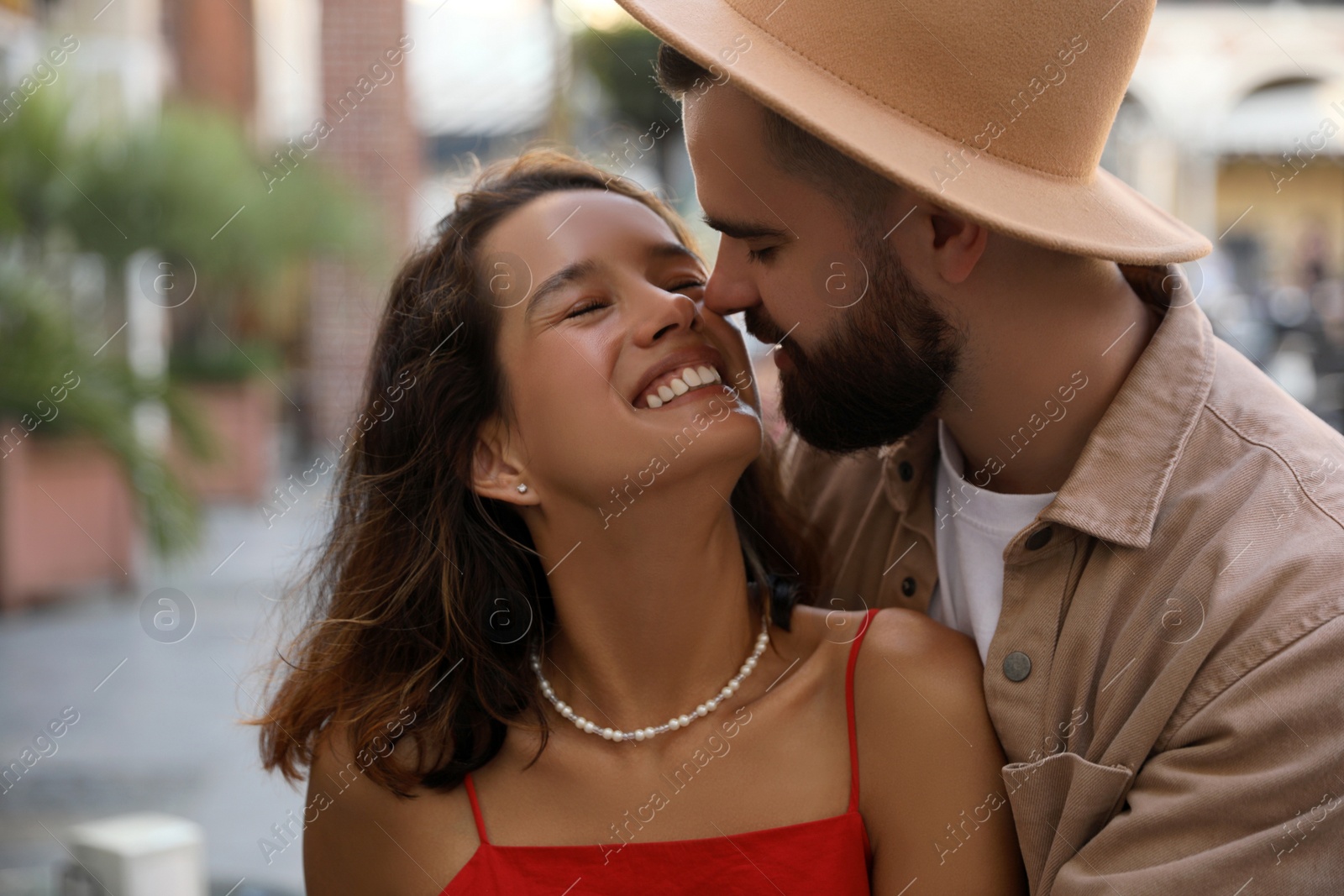 Photo of Happy young couple kissing on city street