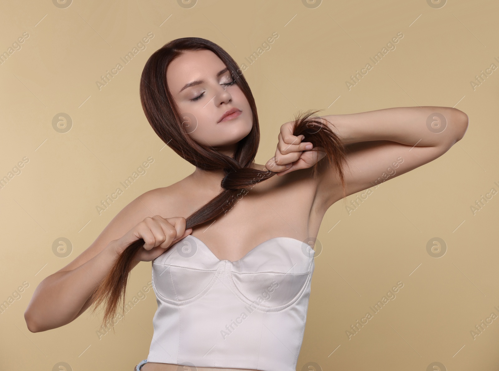 Photo of Portrait of beautiful young woman with healthy strong hair on beige background