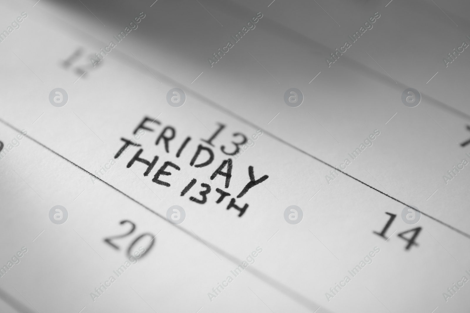 Photo of Calendar page with phrase Friday The 13th, closeup. Superstition of bad luck