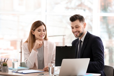 Photo of Young consultant working with client in office