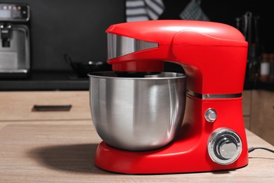 Photo of Modern stand mixer on wooden table in kitchen