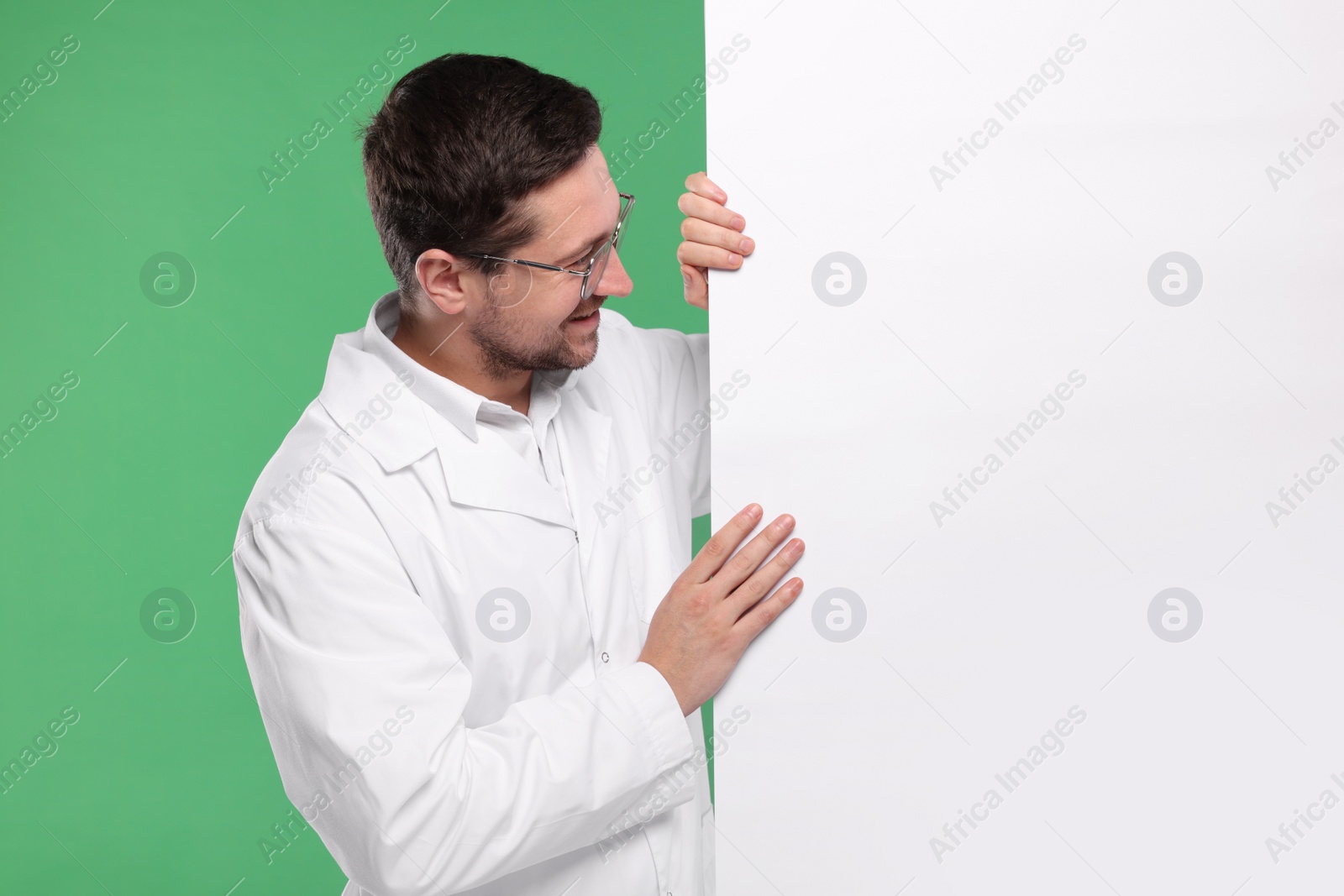 Photo of Ophthalmologist with blank banner on green background, space for text
