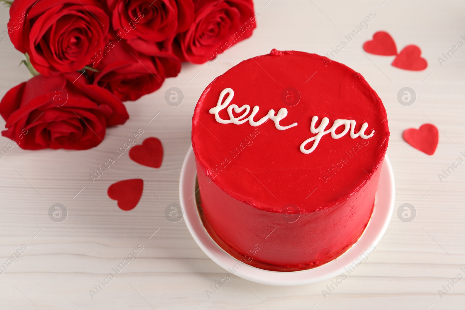 Photo of Bento cake with text Love You, roses and paper hearts on white wooden table, space for text. St. Valentine's day surprise