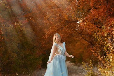 Photo of Beautiful girl wearing fairy dress in autumn forest