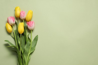 Photo of Beautiful colorful tulip flowers on pale olive background, flat lay. Space for text