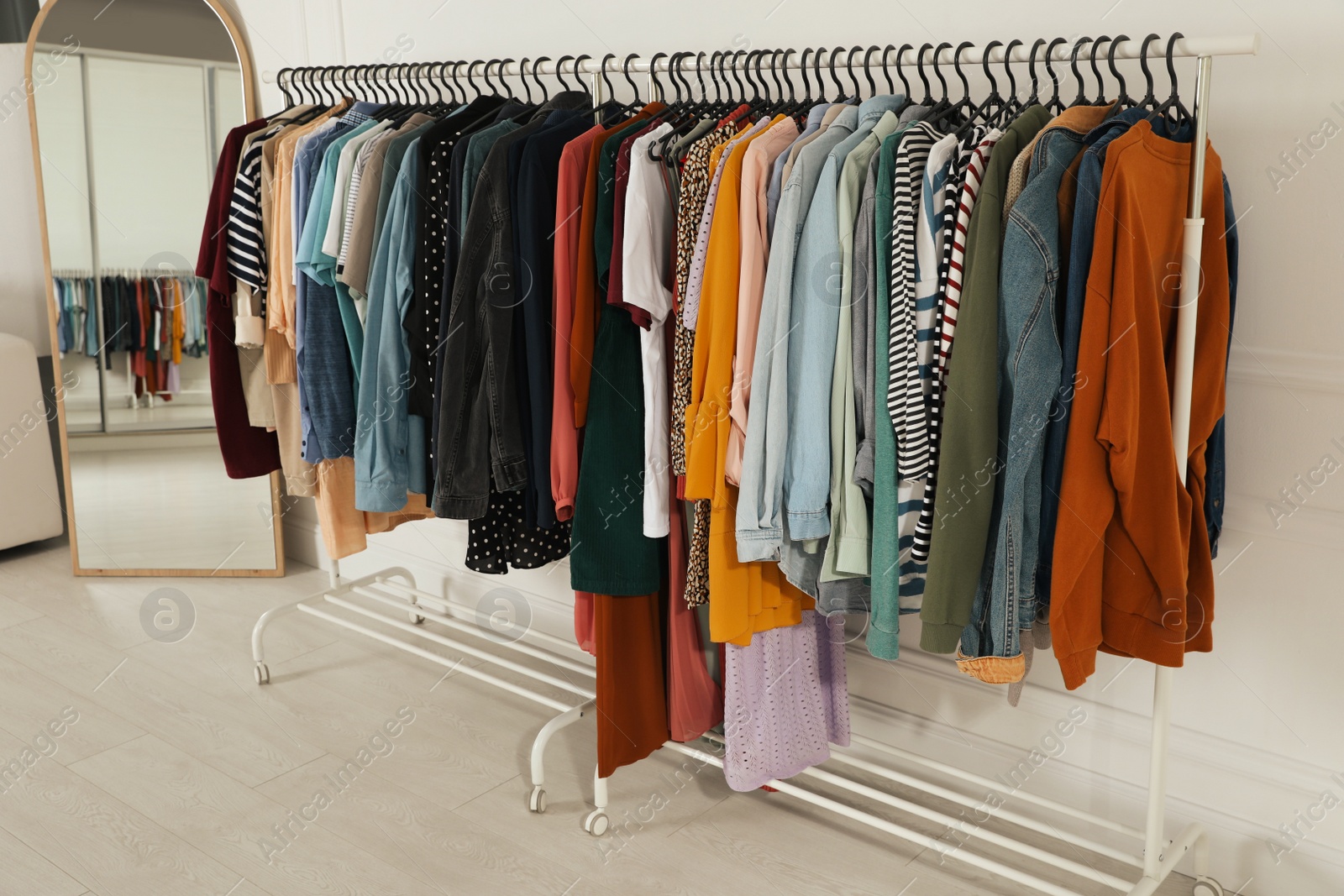 Photo of Racks with stylish clothes indoors. Fast fashion