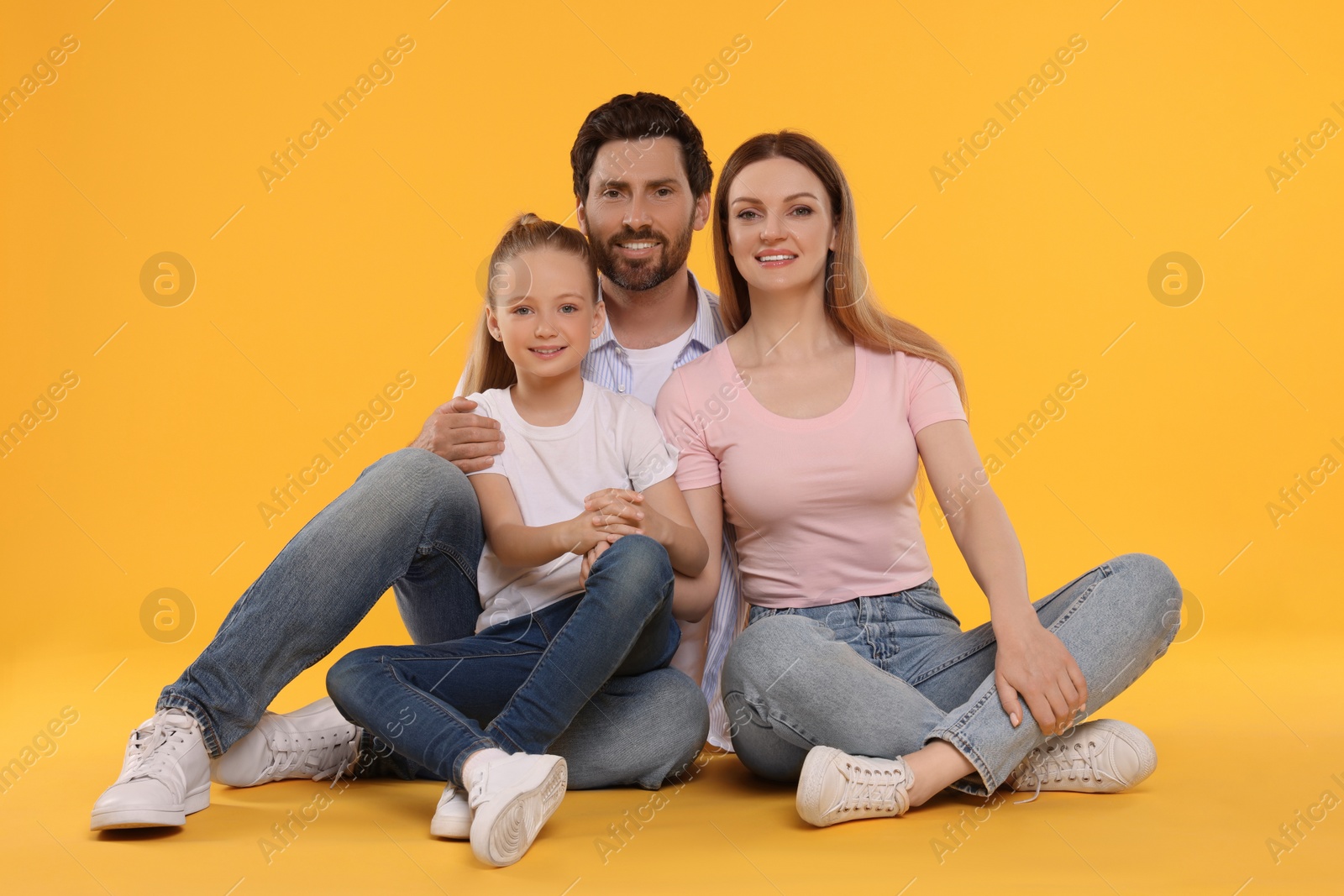 Photo of Portrait of happy family on orange background