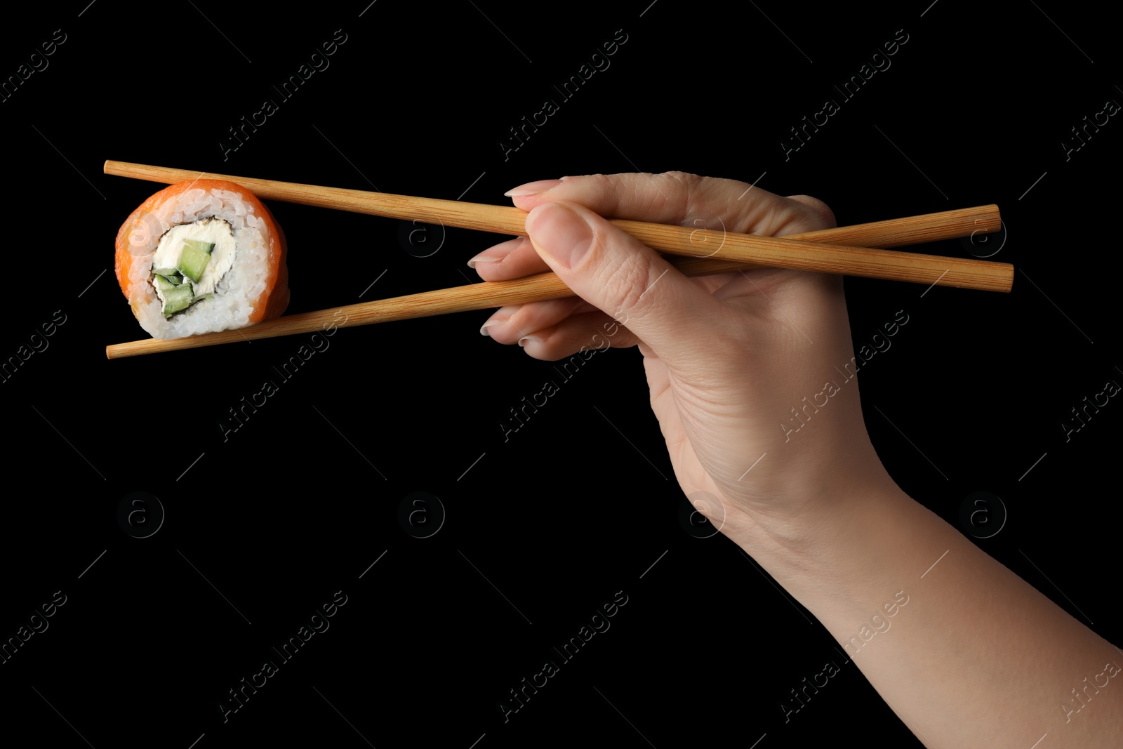 Photo of Woman holding sushi roll with chopsticks on black background, closeup