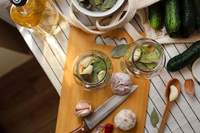 Photo of Empty glass jars and ingredients prepared for canning on table, flat lay