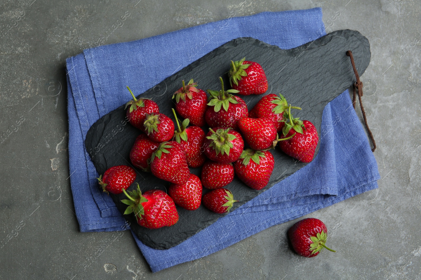 Photo of Delicious ripe strawberries on grey table, flat lay