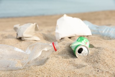 Photo of Garbage scattered on beach near sea, closeup. Recycling problem