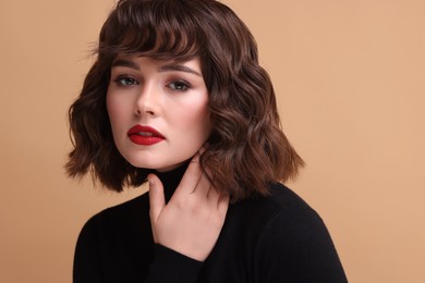 Photo of Portrait of beautiful young woman with wavy hairstyle on beige background