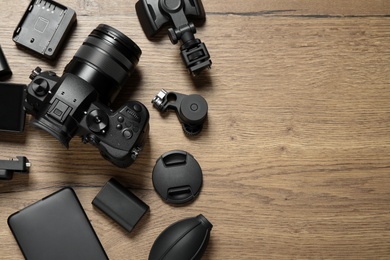 Flat lay composition with camera and video production equipment on wooden background. Space for text