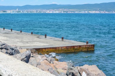 Photo of Beautiful view of coastal city and concrete pier on sunny day