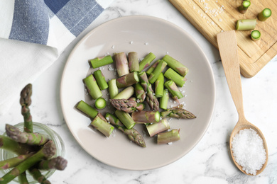Photo of Fresh raw asparagus on white marble table, flat lay