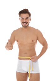 Photo of Fit man measuring his waist on white background. Weight loss