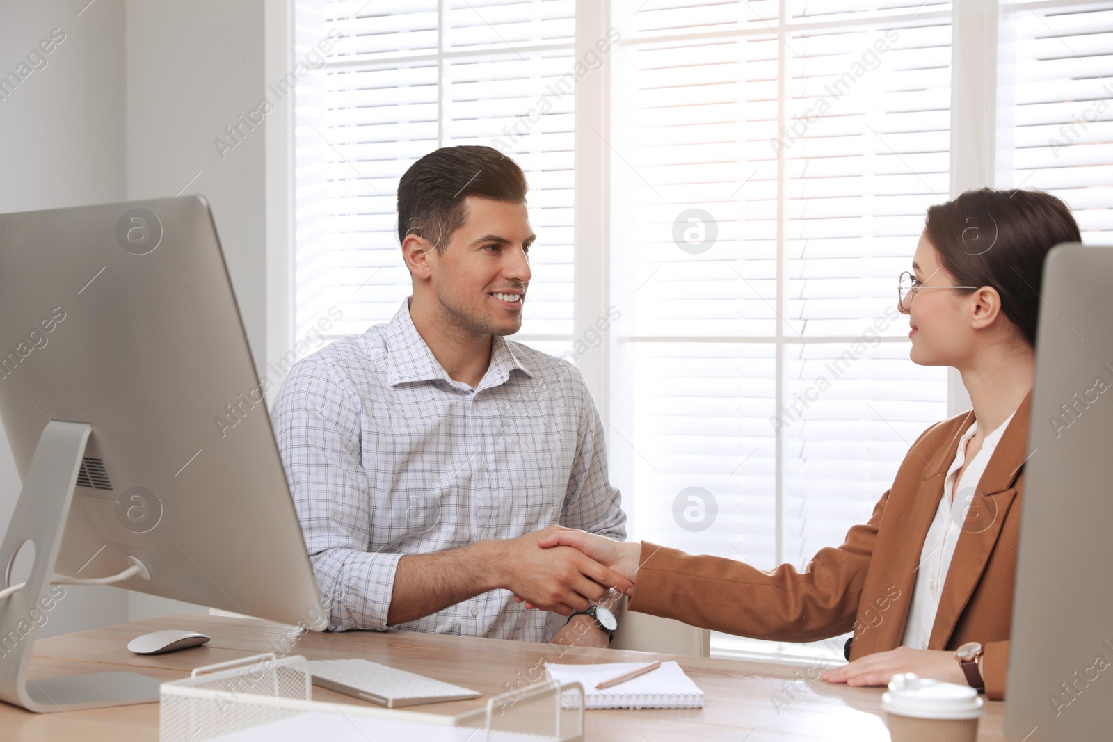 Photo of Employee shaking hands with intern in office