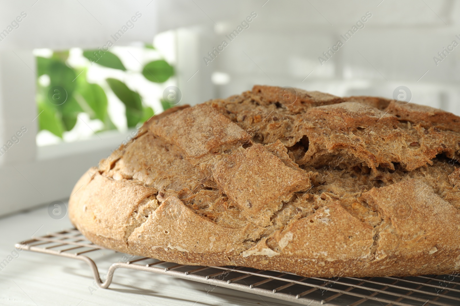 Photo of Freshly baked sourdough bread on white wooden table indoors