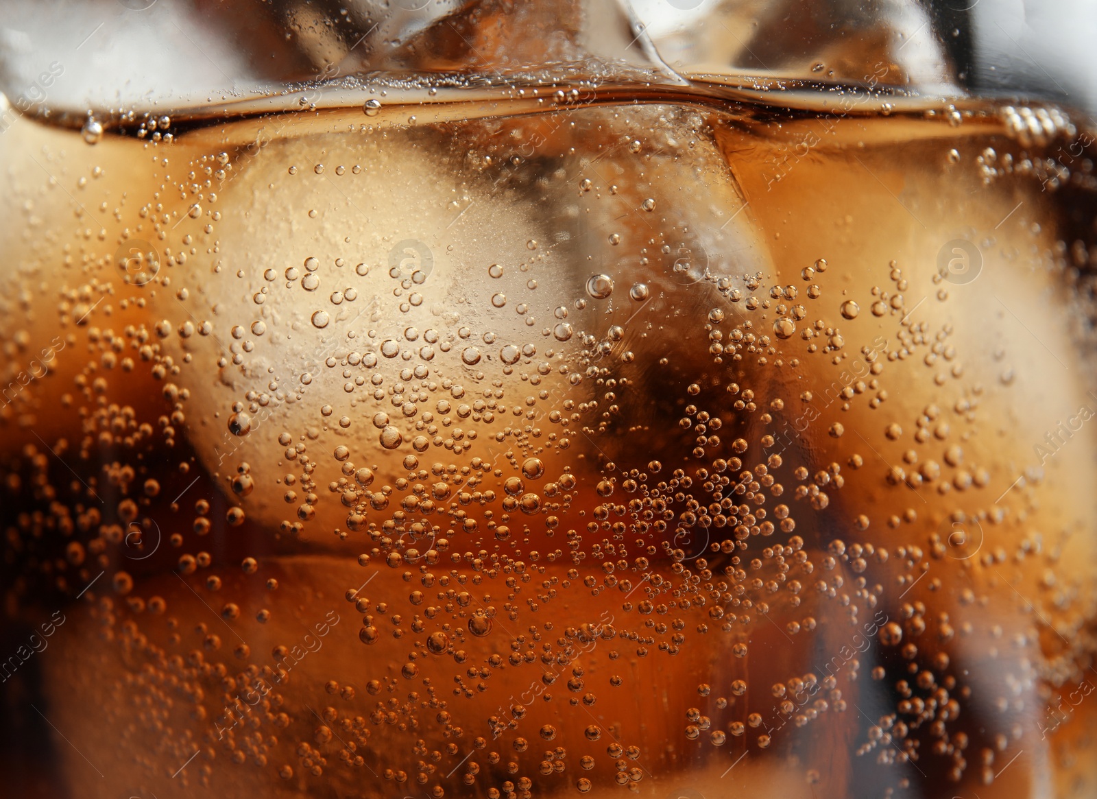 Photo of Glass of tasty refreshing cola with ice cubes, closeup