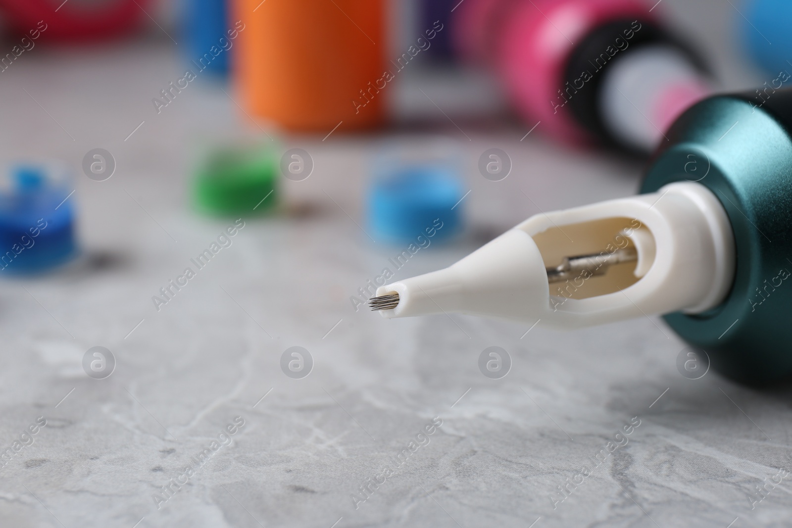 Photo of Professional tattoo machine on light grey table, closeup. Space for text