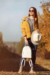 Photo of Young woman with stylish backpack on autumn day