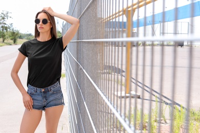 Photo of Young woman wearing black t-shirt on street. Urban style