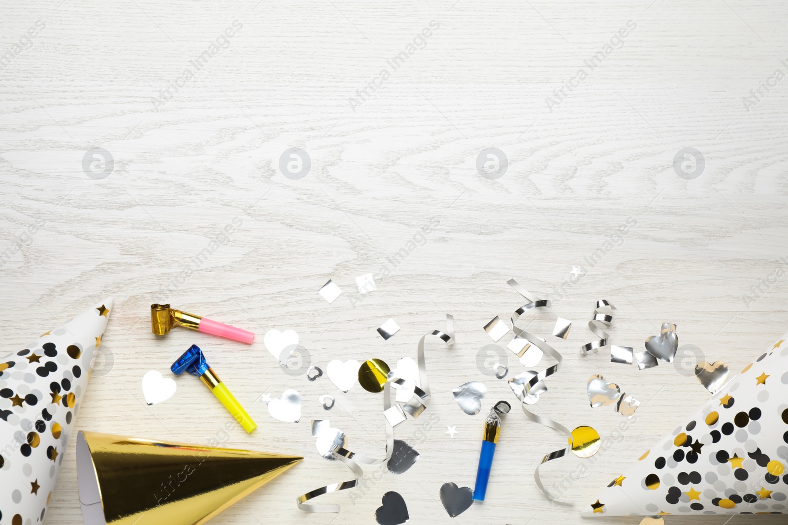 Photo of Flat lay composition with party items on white wooden table, space for text