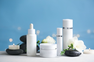 Beautiful composition with cosmetic products and spa stones on white table