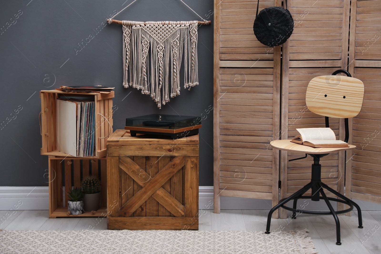 Photo of Stylish turntable on wooden crate in room