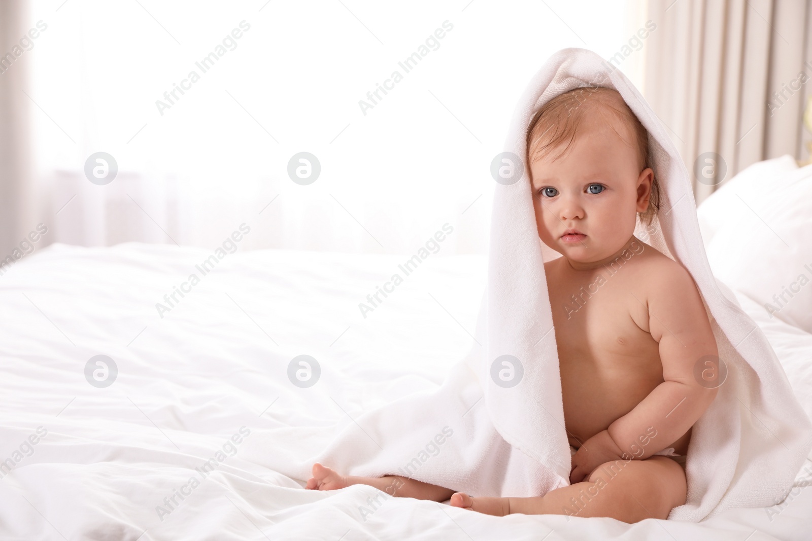 Photo of Cute little baby with soft towel on bed after bath. Space for text