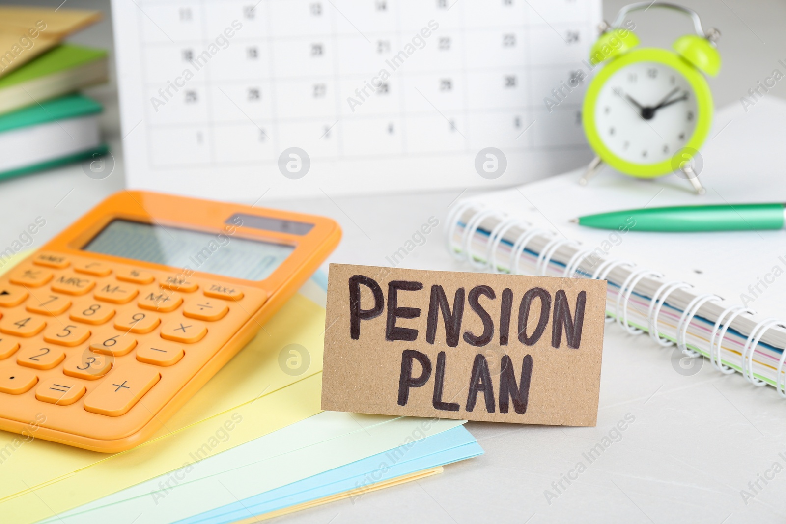 Photo of Card with words Pension Plan, calculator and stationery on white office table, closeup