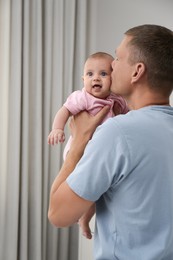 Father holding his cute baby at home