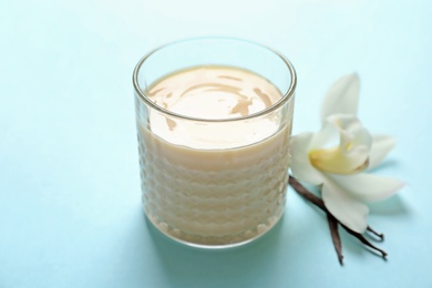 Photo of Vanilla pudding, sticks and flower on color background