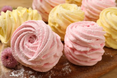 Photo of Delicious pink and yellow marshmallows on wooden board, closeup