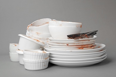 Photo of Set of dirty dishes on grey background