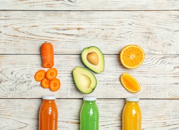 Flat lay composition with tasty juices and ingredients on wooden background