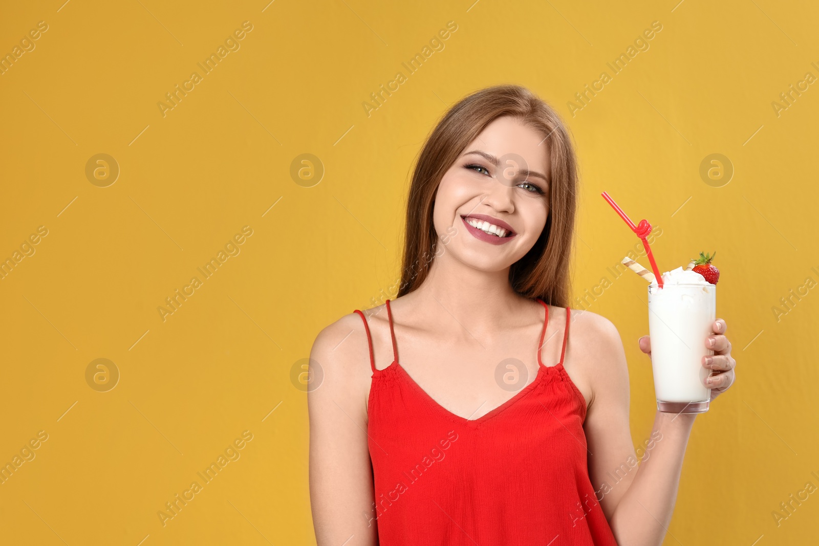 Photo of Young woman with glass of delicious milk shake on color background