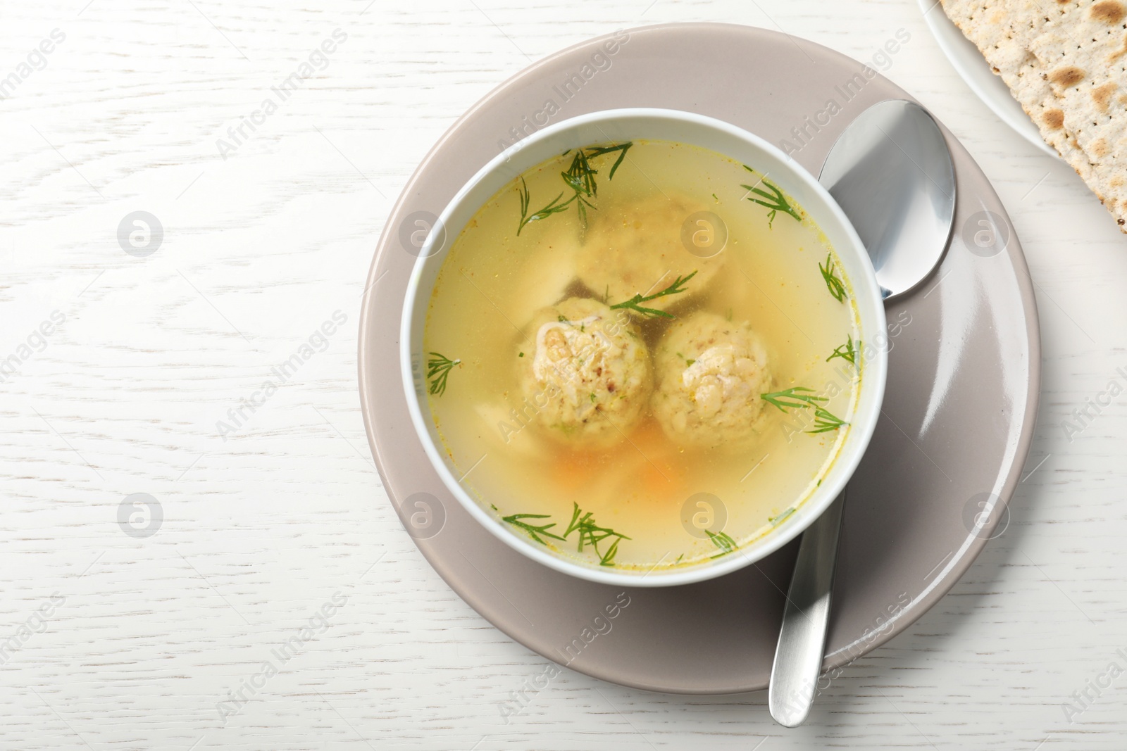 Photo of Flat lay composition with Jewish matzoh balls soup on white wooden table. Space for text